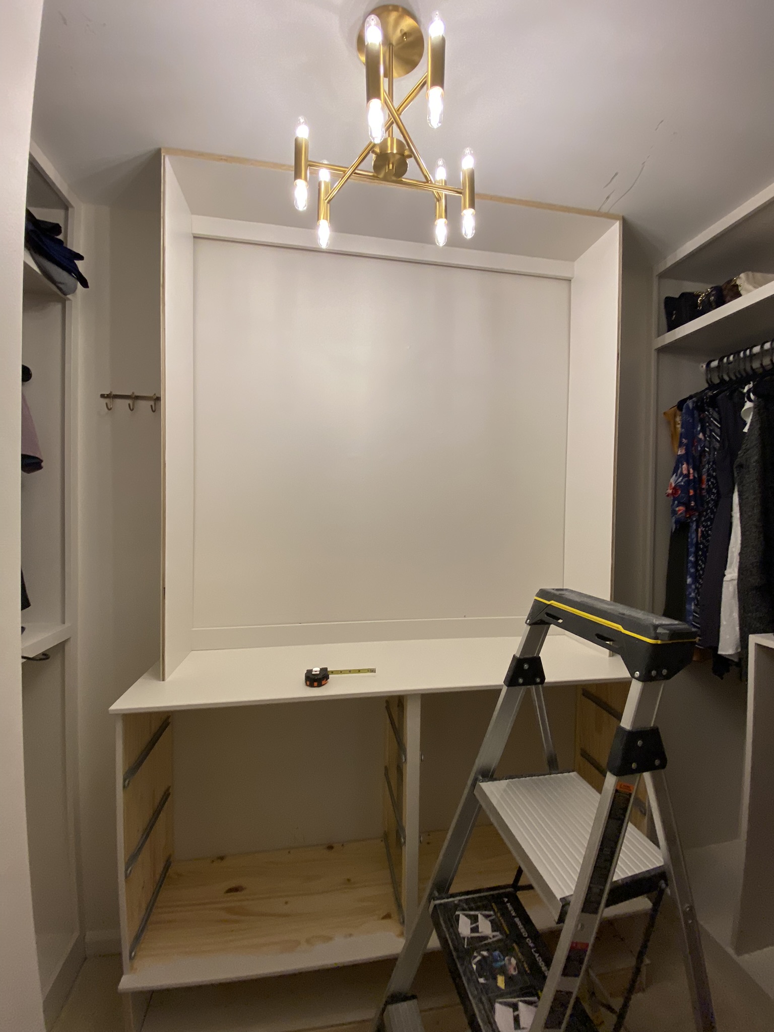 Frame of custom DIY built-ins installed in small walk in closet.