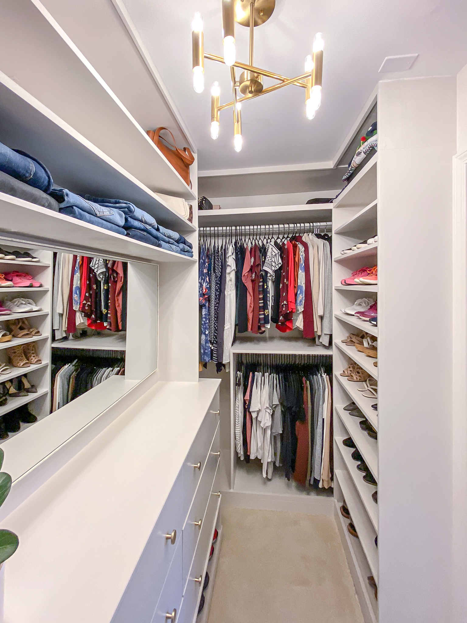 DIY Custom Closet white Built Ins with gold finishes and a large mirror.
