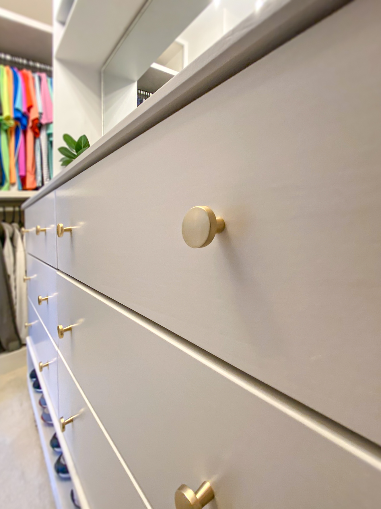 Gold cabinet knobs on a creamy white dresser drawer in DIY custom built in closet makeover.