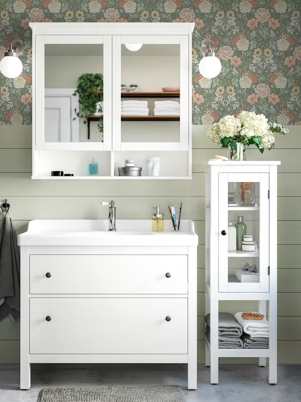 A white HEMNES mirror cabinet with two doors, a white sink cabinet with two drawers and a high cabinet with glass door.