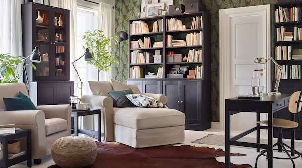 Two light beige IKEA GRÖNLID armchairs in a living room with HAVSTA dark brown glass cabinets and shelves.