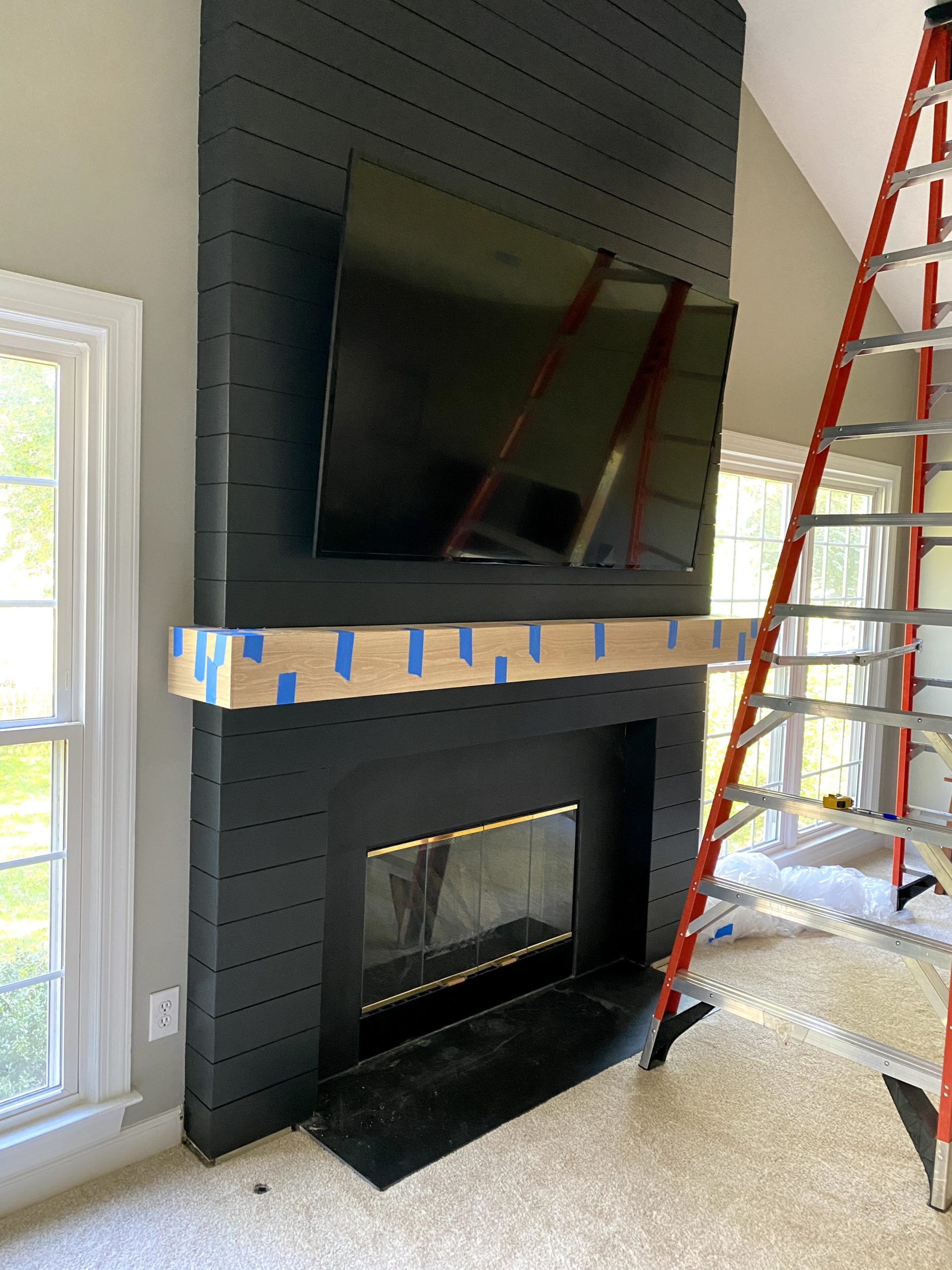 DIY Modern Shiplap Fireplace painted in dark blue with white oak mantel.